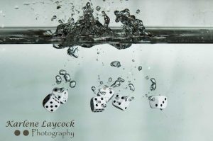 White Dice falling into water on grey 2