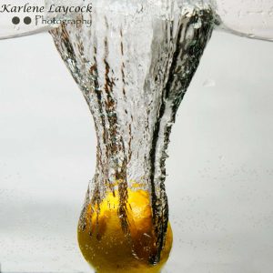 Lemon falling into water on grey 2