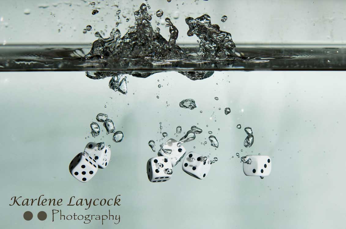 White Dice falling into water on grey series 4