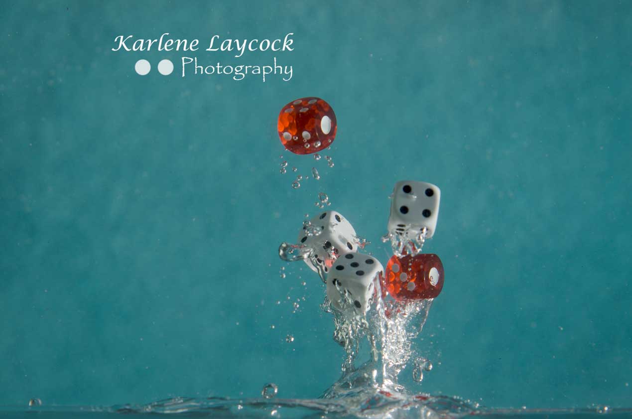 Red Dice falling into water on blue 3