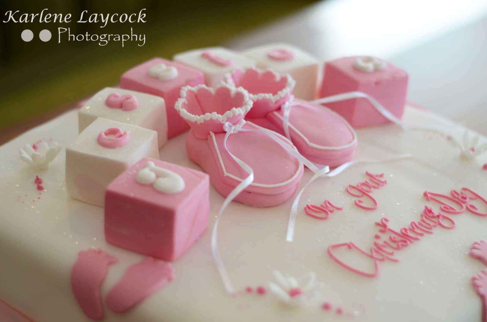 Photograph of a Pink Christening Cake with Booties and Building Blocks