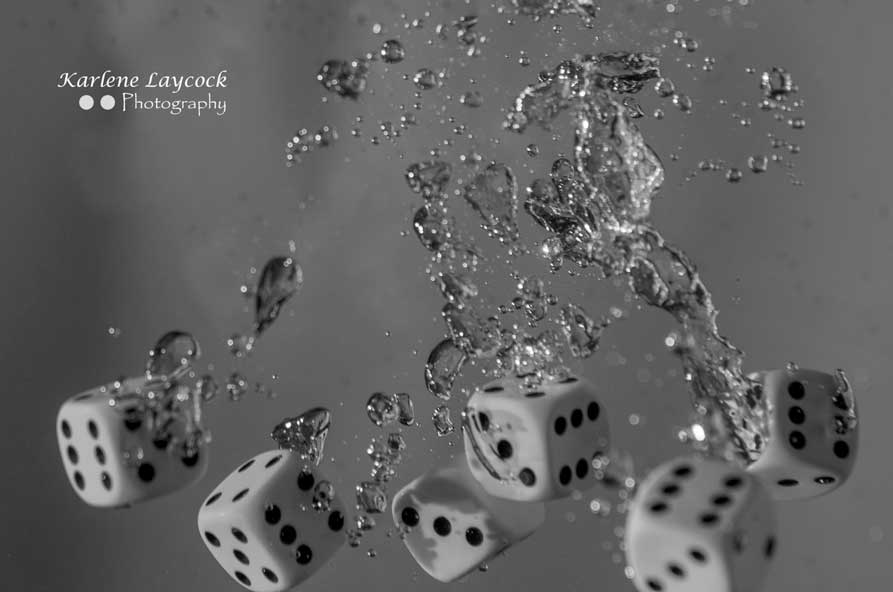 High Speed Photography - Six White Dice Floating against a Grey Background